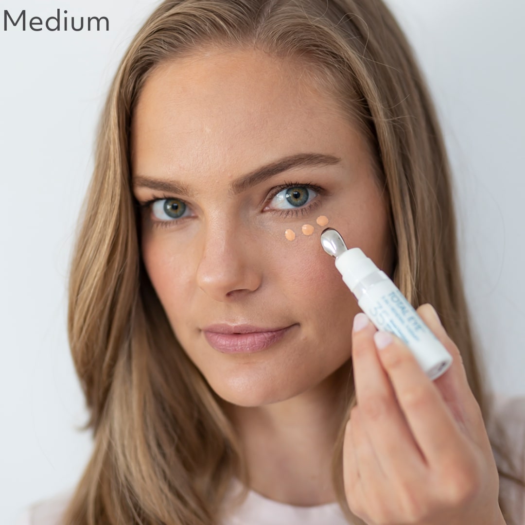 Woman displaying Total Eye® 3-IN-1 Renewal Therapy in medium shade