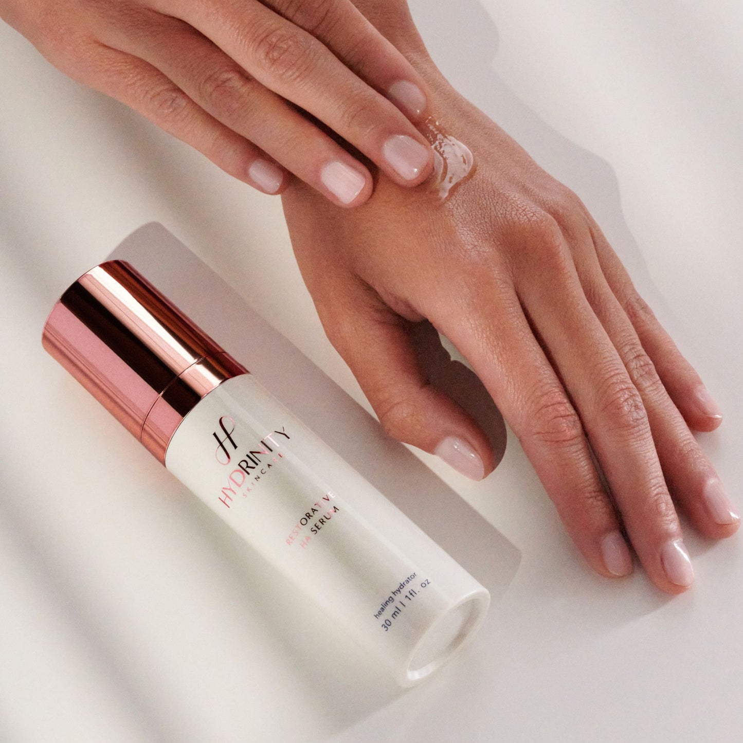 A woman applying Hydrinity Restorative HA Serum to her hand