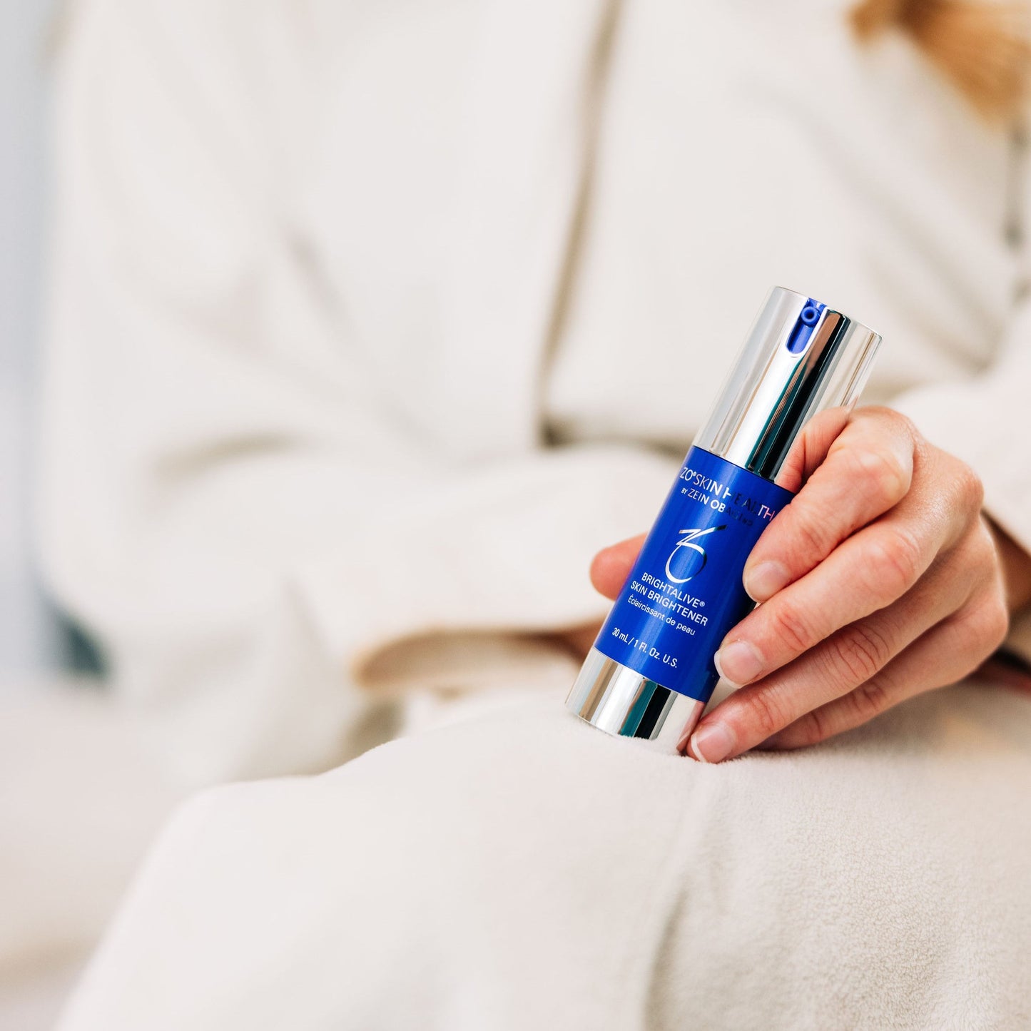 A woman holding the ZO Skin Health Brightalive Travel Size