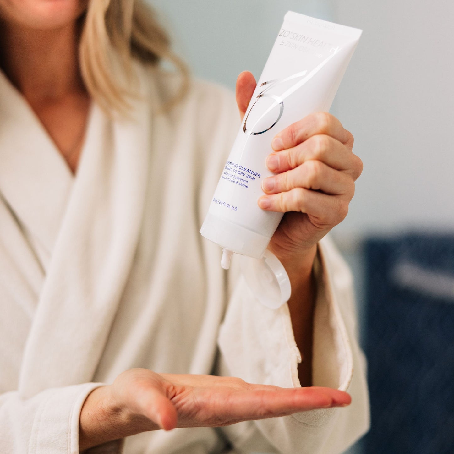 A woman in her bathroom using ZO Skin Health Hydrating Cleanser