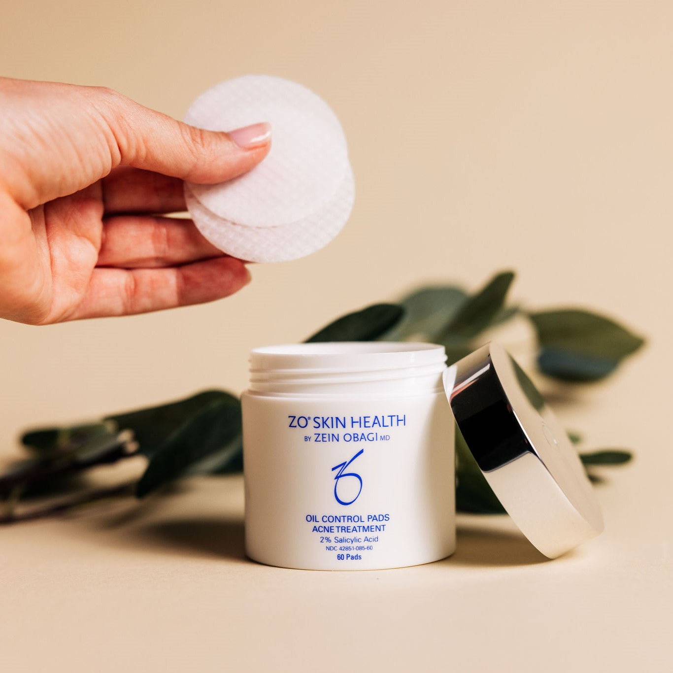 Someone showing what the Oil Control Pads from ZO Skin Health look like