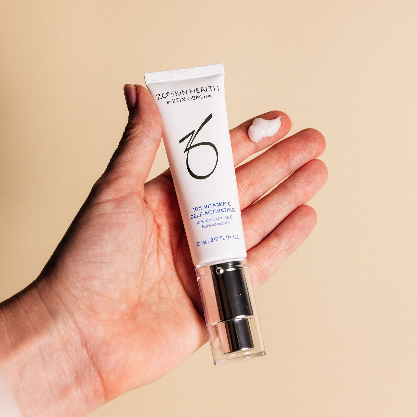 A hand holding the ZO Skin Health 10% Vitamin C Self-Activating in travel size