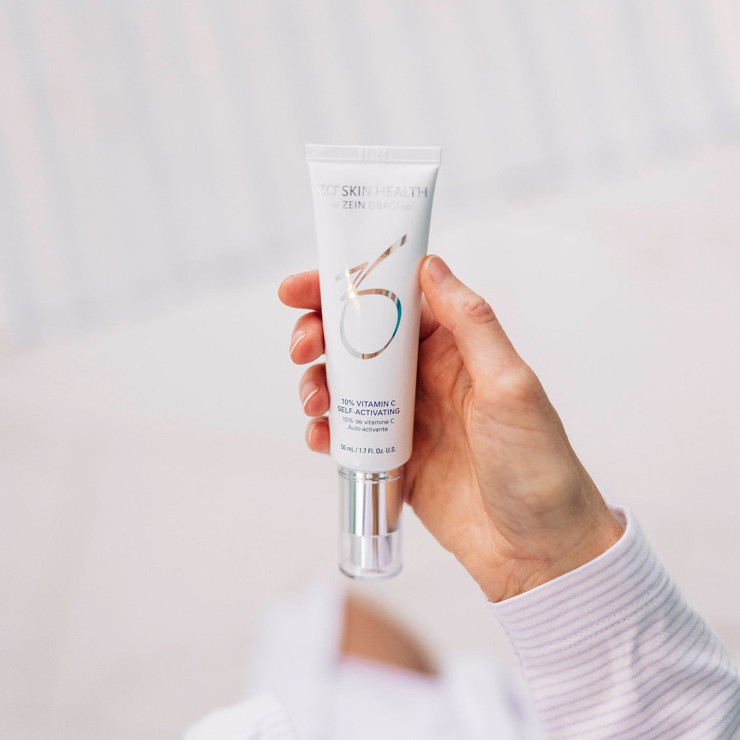 A woman's hand holding ZO Vitamin C 10% Self-Activating