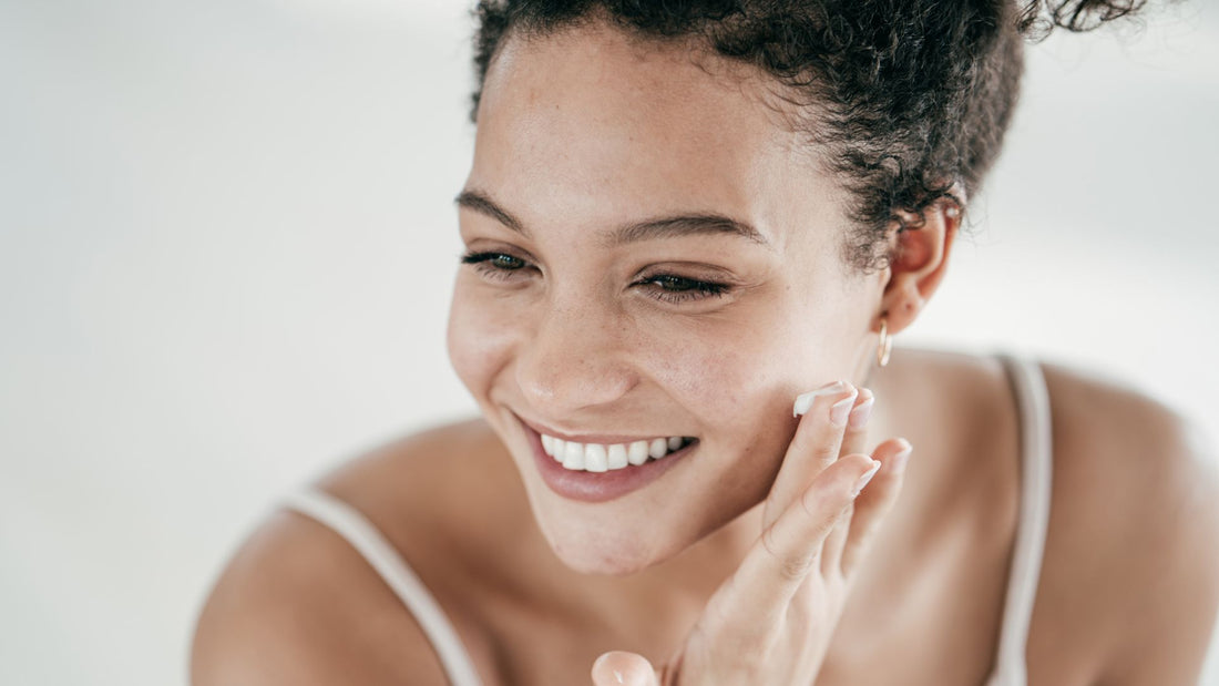 A woman applying retinol to her face