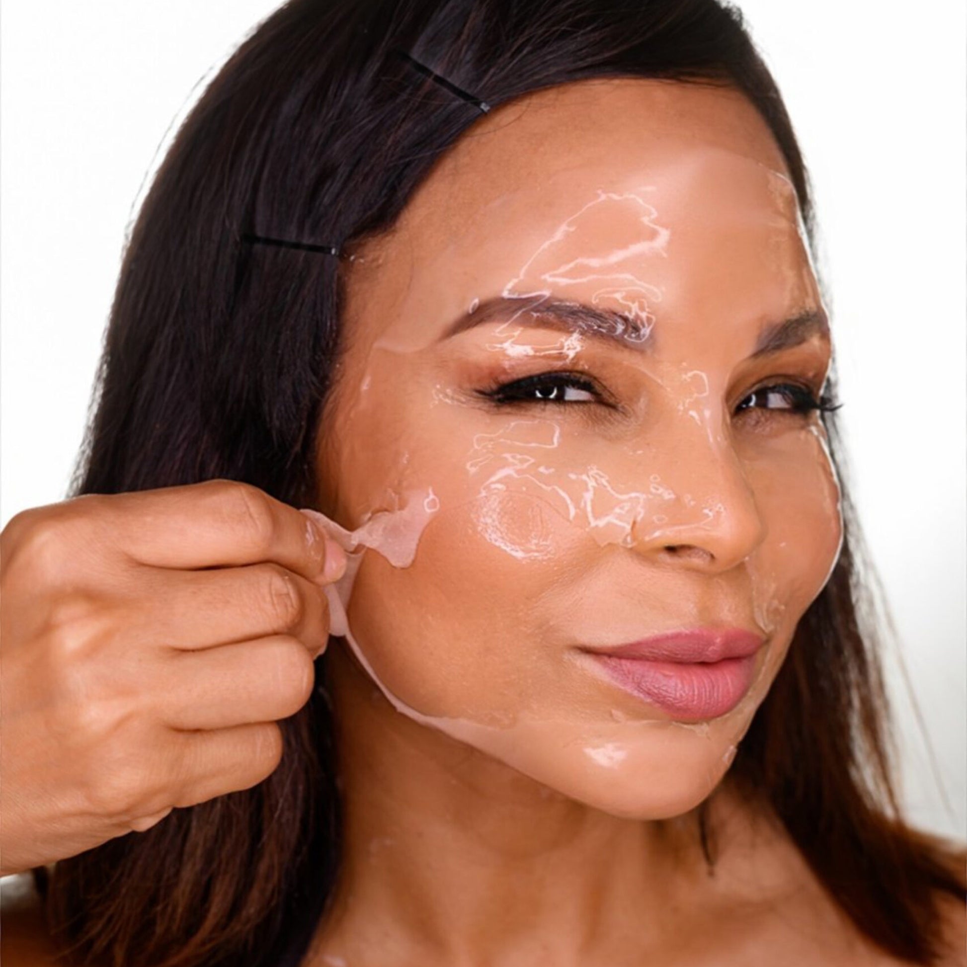 A woman peeling off the CO2Lift Pro carboxytherapy gel mask treatment from her face