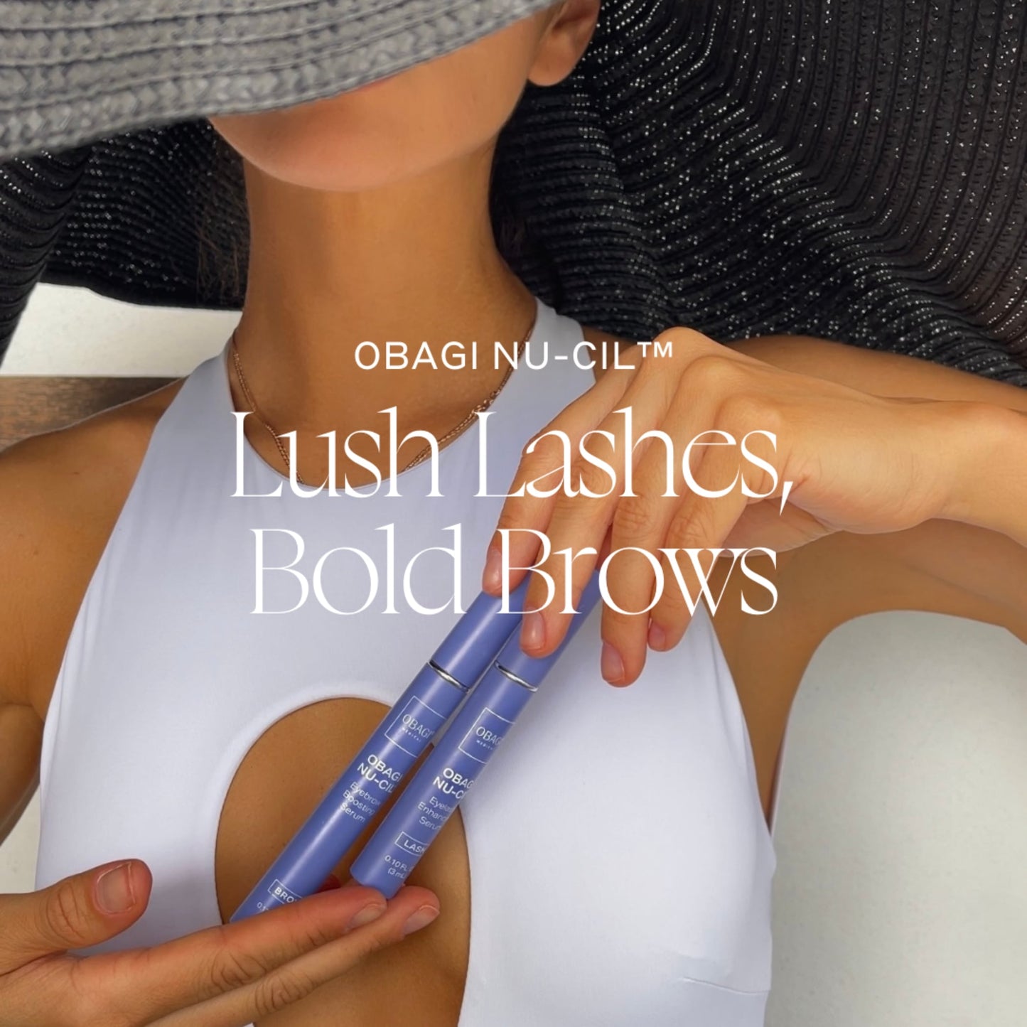 A woman holding the Obagi Eyelash and Eyebrow Growth Serum tubes in her hands