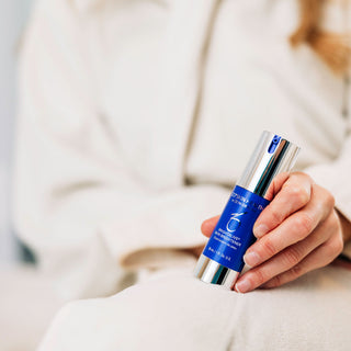 A woman holding ZO Skin Health's Brightalive Skin Brightener