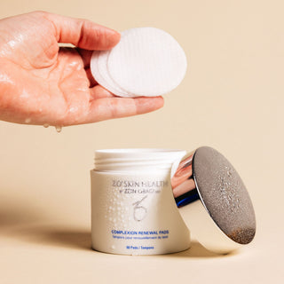 A hand holding individual ZO Skin Health presoaked Complexion Renewal Pads
